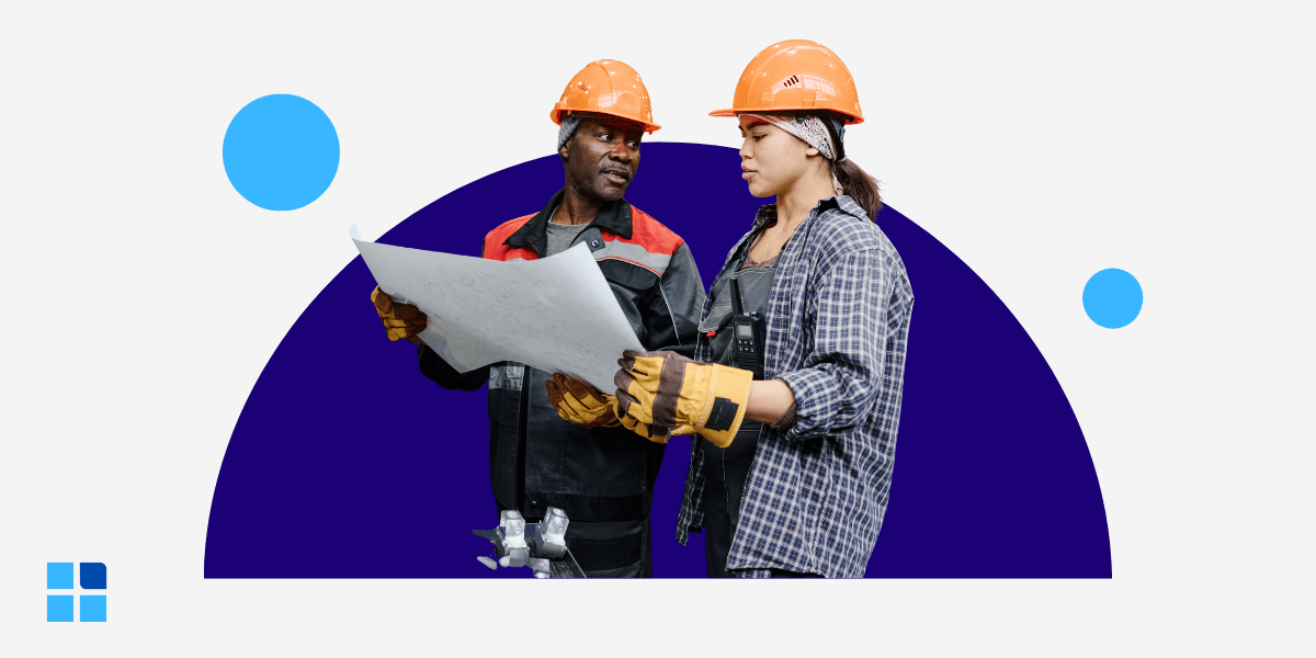 Two factory engineers in hard hats reviewing blueprints.