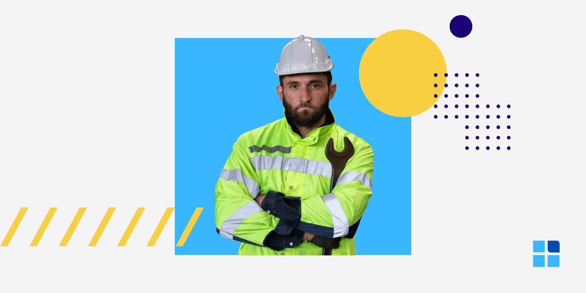 An industrial engineer in a hard hat and safety jacket, holding a large wrench.