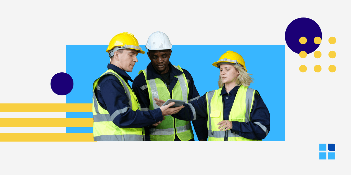 Three construction workers wearing yellow safety vests and helmets discuss a tablet.
