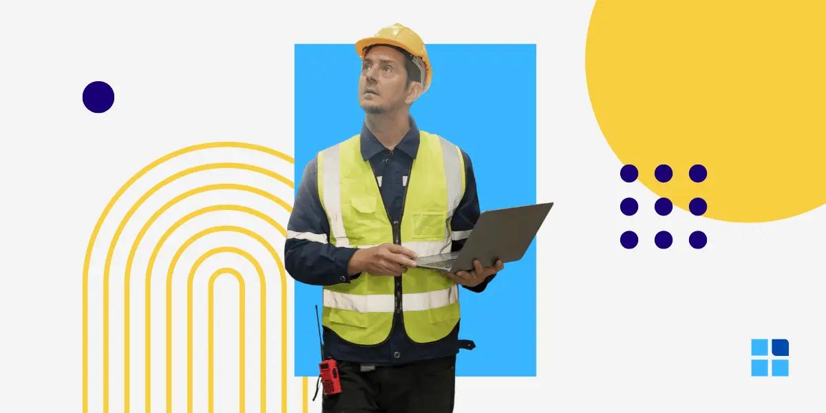 A construction worker in a yellow vest and helmet holds a laptop, looking up.