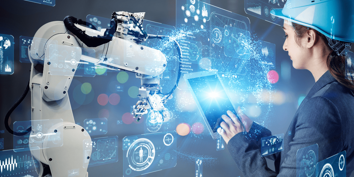 An engineer in a hard hat uses a tablet with a glowing holographic interface to program or analyze a white robotic arm in a smart factory.