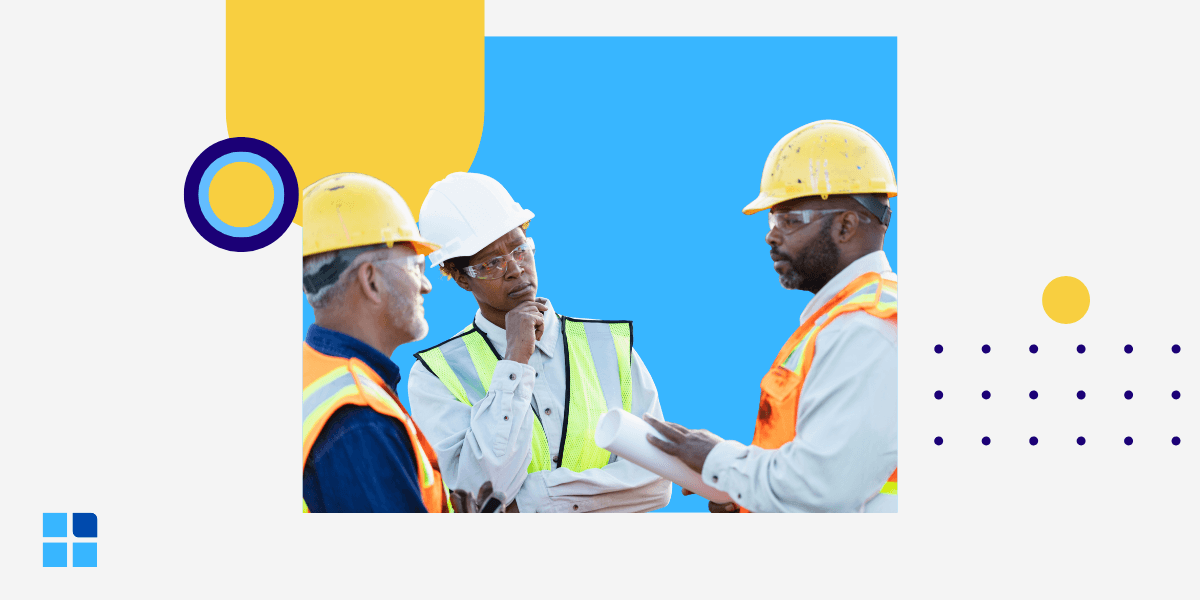 Three construction workers in safety gear discuss a blueprint.