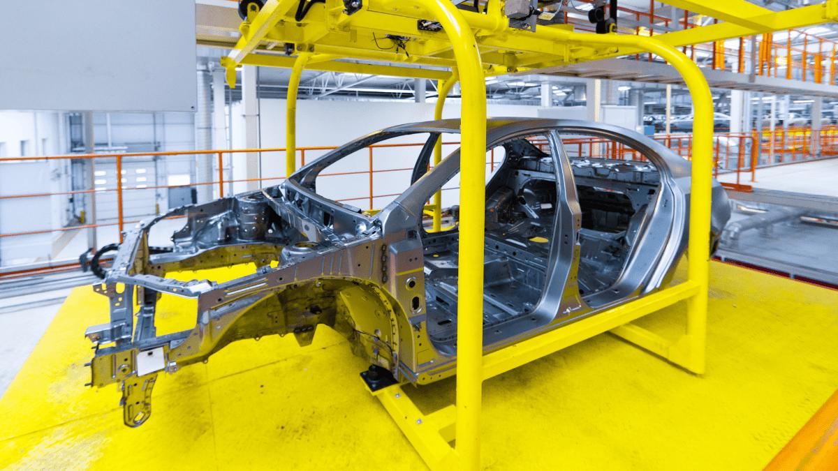 A car frame on an automotive assembly line.