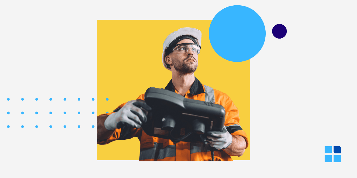 Man in an orange safety uniform holds a device, looking focused.