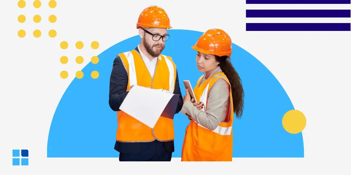 Two construction workers in orange safety vests and helmets discuss a document on a clipboard.